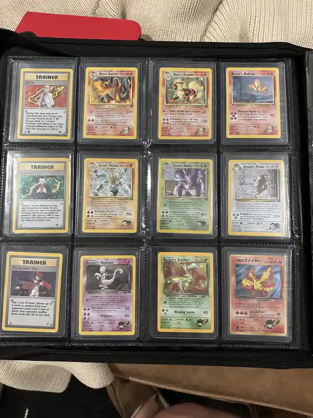 A collection of ten Pokémon trading cards displayed in a black portfolio, featuring Blaine's Charizard, Arcanine, and…