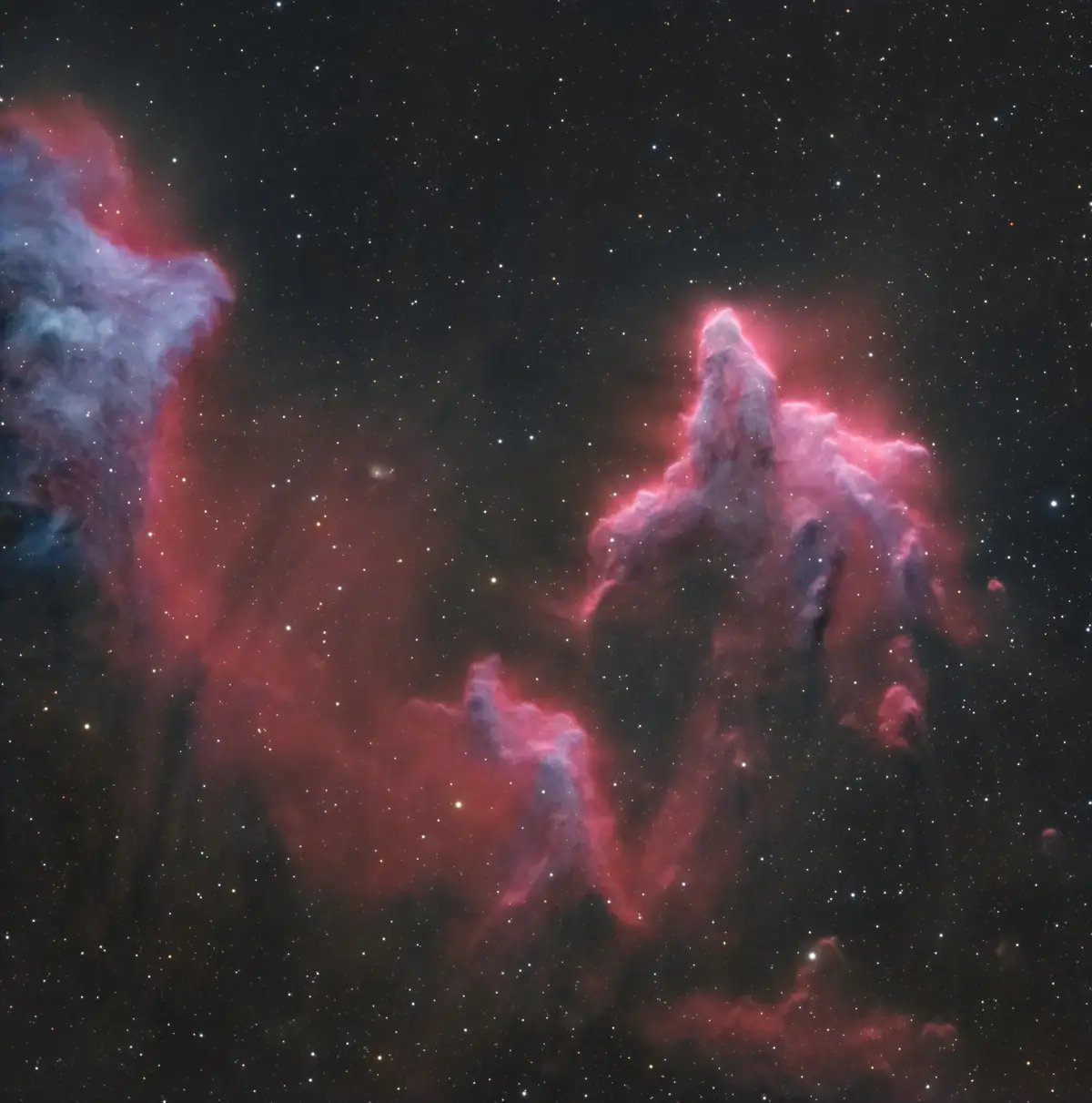 A cosmic image of the Eagle Nebula's Pillars of Creation, showing towering red and blue gas clouds against a starfield…