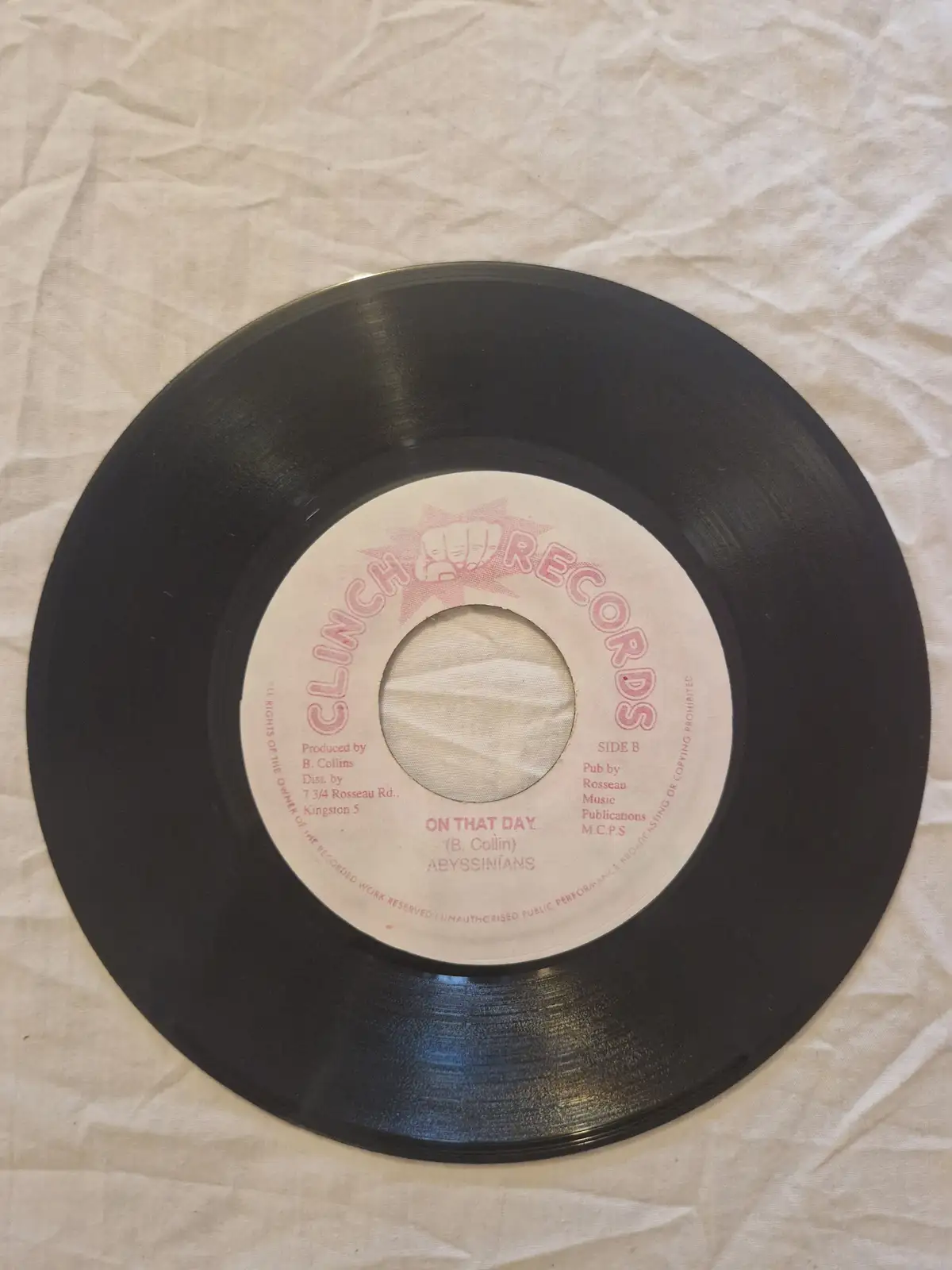 A close-up photo of a black 7-inch vinyl record label from Clinch Records, showing the song title 'ON THAT DAY' by the band…