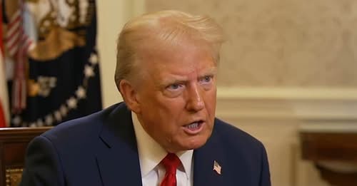 a still image of former president donald trump, wearing a dark suit and red tie, looking slightly to his right with a stern…