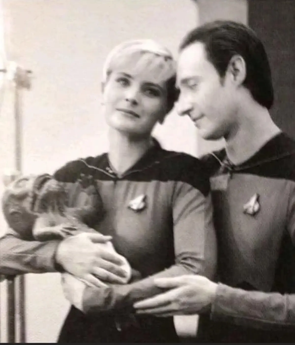 A black-and-white photo shows two actors in Star Trek uniforms, a woman holding a small primate and a man looking at her…