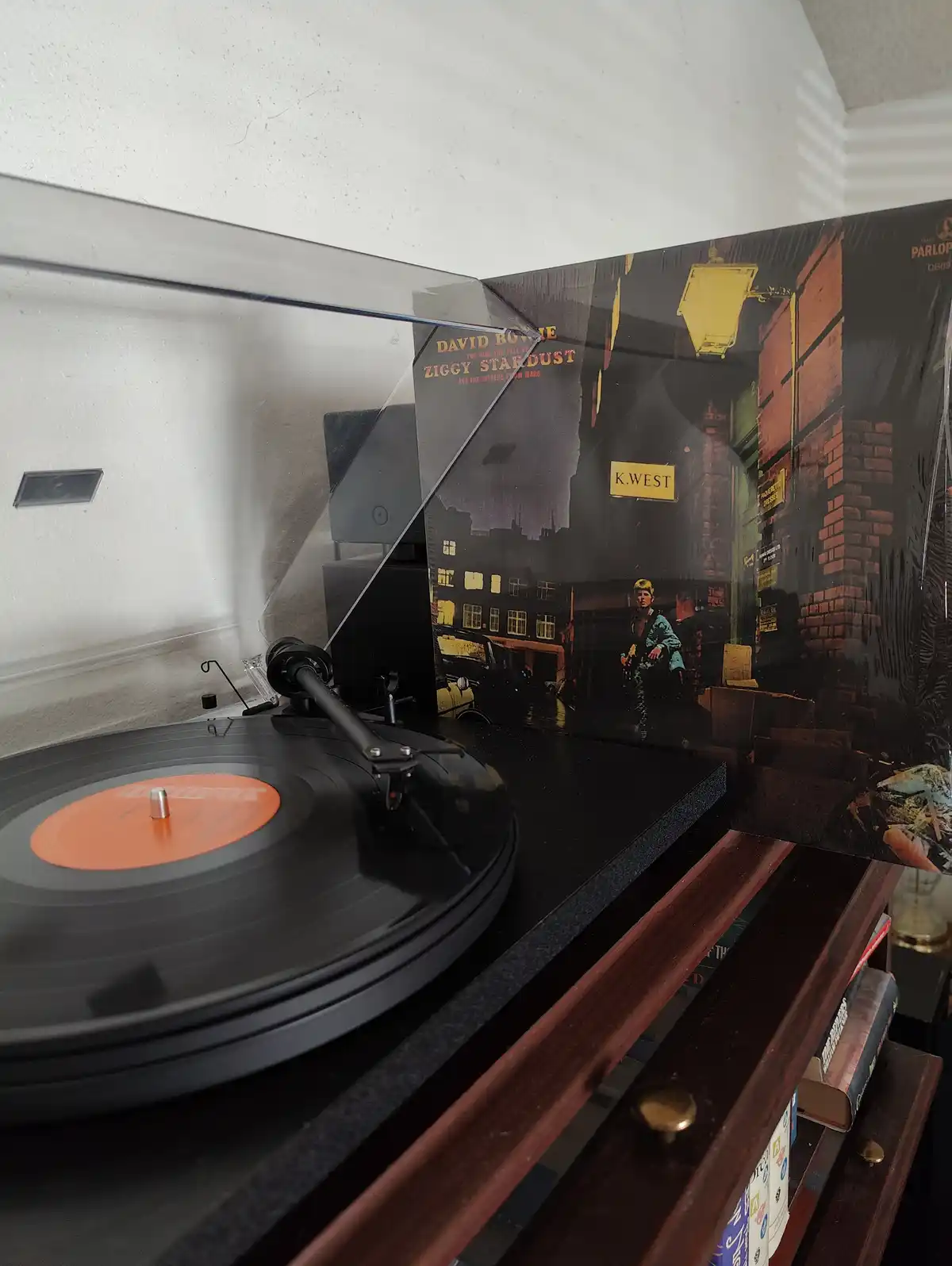 A close-up photo shows a vinyl record player with a record spinning on the platter, and the album cover for David Bowie's…