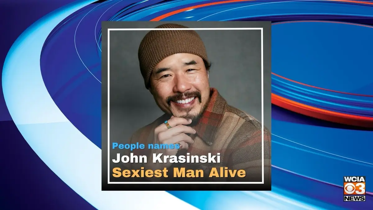A news broadcast-style graphic features a smiling man wearing a brown beanie and plaid shirt, with text overlay identifying…