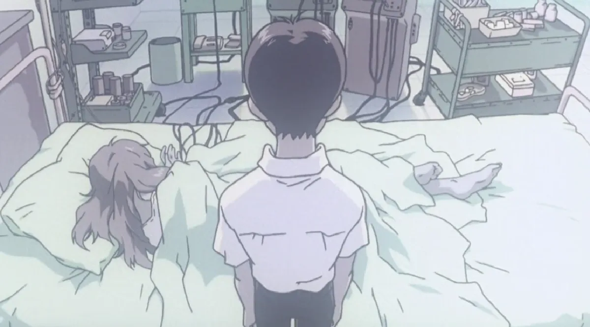 An anime scene shows a young man standing beside a hospital bed where a girl lies under white sheets, surrounded by medical…