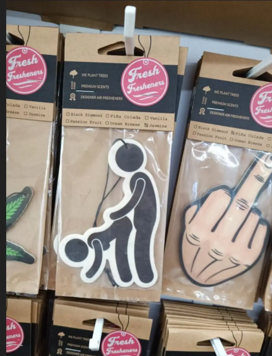 A shelf of 'Fresh Fresheners' air freshener packages, with one prominently displaying a black silhouette of a person doing a…