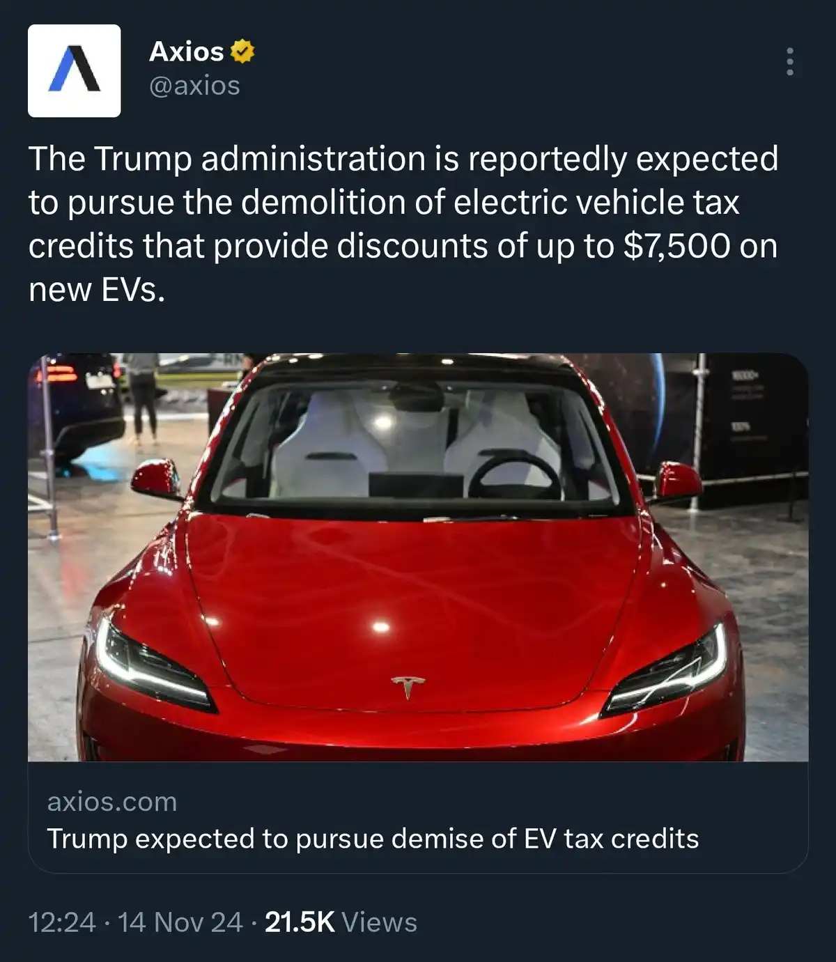 A screenshot of an Axios tweet showing a red Tesla car from the front, with white seats visible inside. The tweet text…