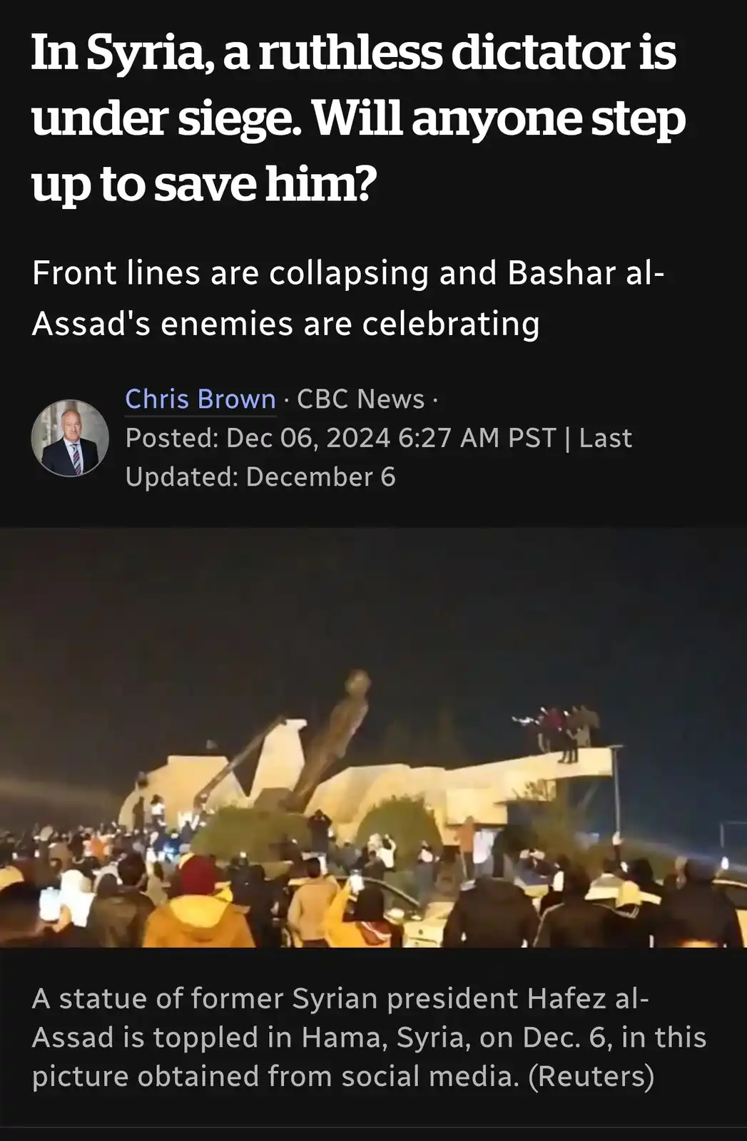 The image shows a nighttime scene where a large statue of former Syrian president Hafez al-Assad is being toppled by a…