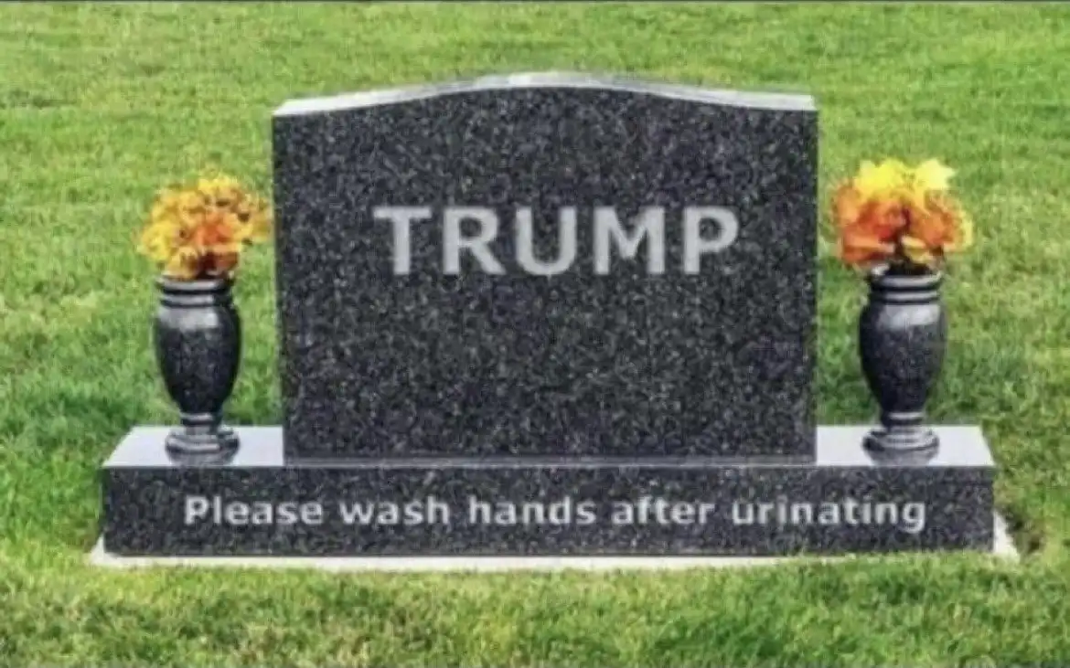 A black granite tombstone with the name 'TRUMP' engraved on its face, flanked by two black vases with yellow-orange flowers…