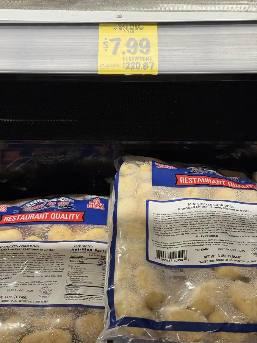 A supermarket freezer shelf displays bags of 'Mini Chicken Corn Dogs' labeled 'Restaurant Quality'. A yellow price tag above…