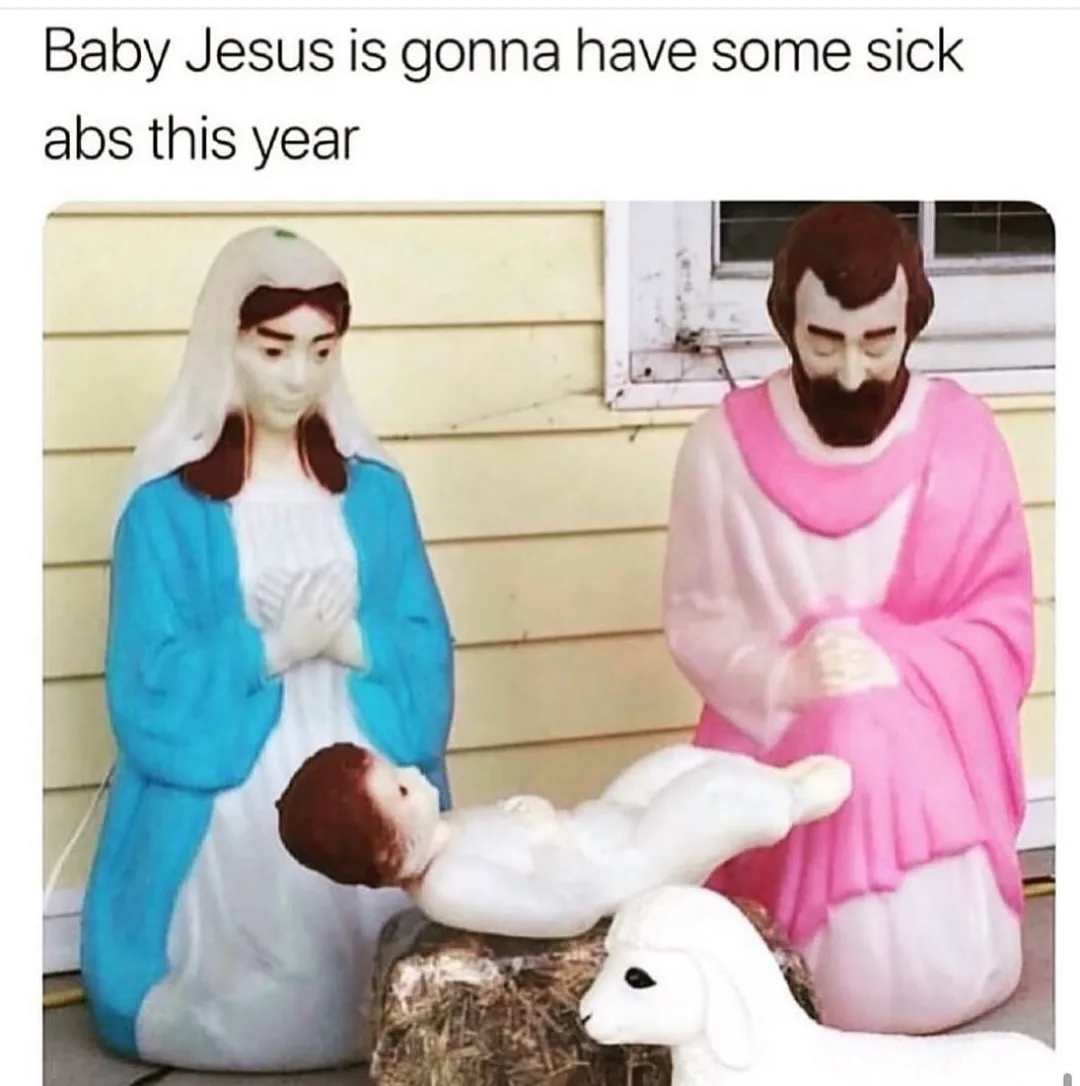 An outdoor nativity scene featuring plastic statues of Mary in blue and white robes, Joseph in pink robes, and a baby Jesus…