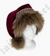 A white mannequin head wears a maroon winter hat with a wide, fluffy brown fur trim and a decorative gold-brown patterned…