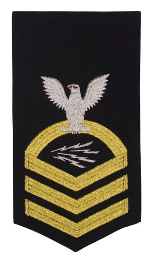 A black military sleeve insignia patch featuring three gold chevrons, a silver eagle with outstretched wings perched atop a…