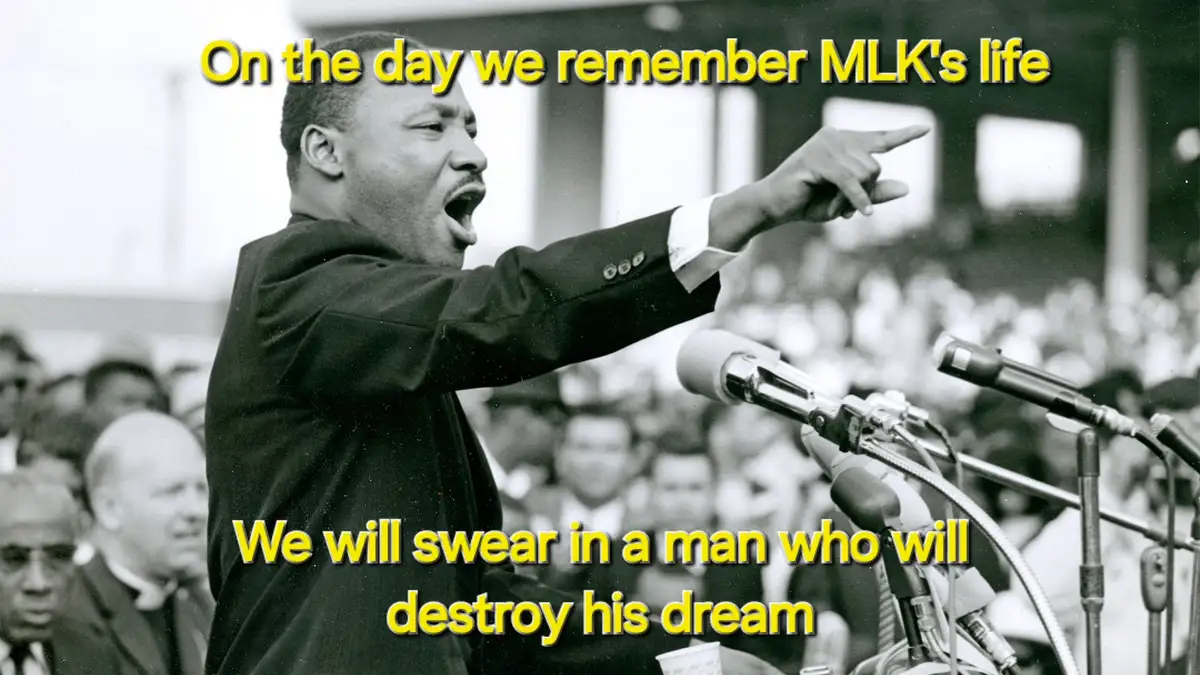 A black and white photo of Martin Luther King Jr. mid-speech, pointing forward with his right hand, standing behind…