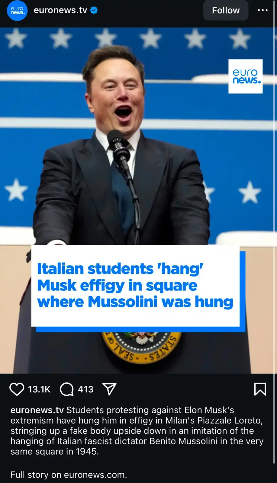 A man in a dark suit stands at a podium with a microphone, mouth open as if shouting, against a blue background with white…