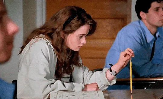 A still from the movie 'Notting Hill' shows a young woman in a light-colored blouse sitting at a desk, looking down at her…