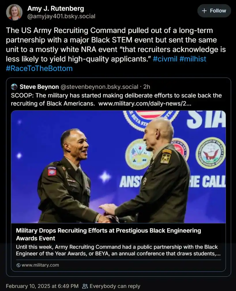 Two men in military uniforms shake hands on a stage with a blue backdrop featuring logos and the text 'ANSWER THE CALL'. The…