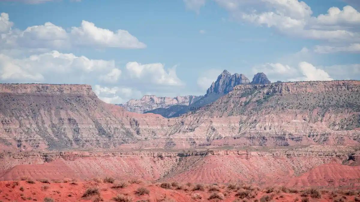 Vibrant red rock formations stand tall against a brilliant blue sky, their rugged textures a testament to the power of…