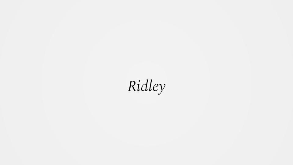 The image displays the word 'Ridley' in a simple black serif font, centered on a plain, light gray background. There are no…