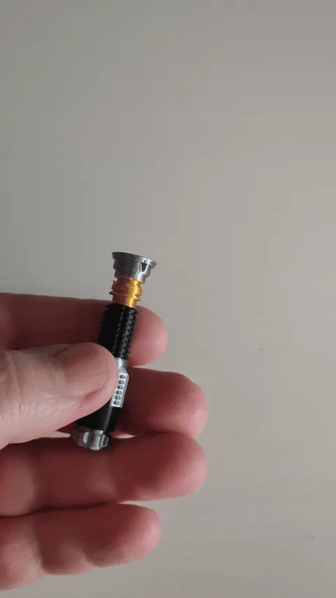 A three-panel image shows a hand holding a small toy lightsaber hilt, then the hilt being unscrewed to reveal a green…