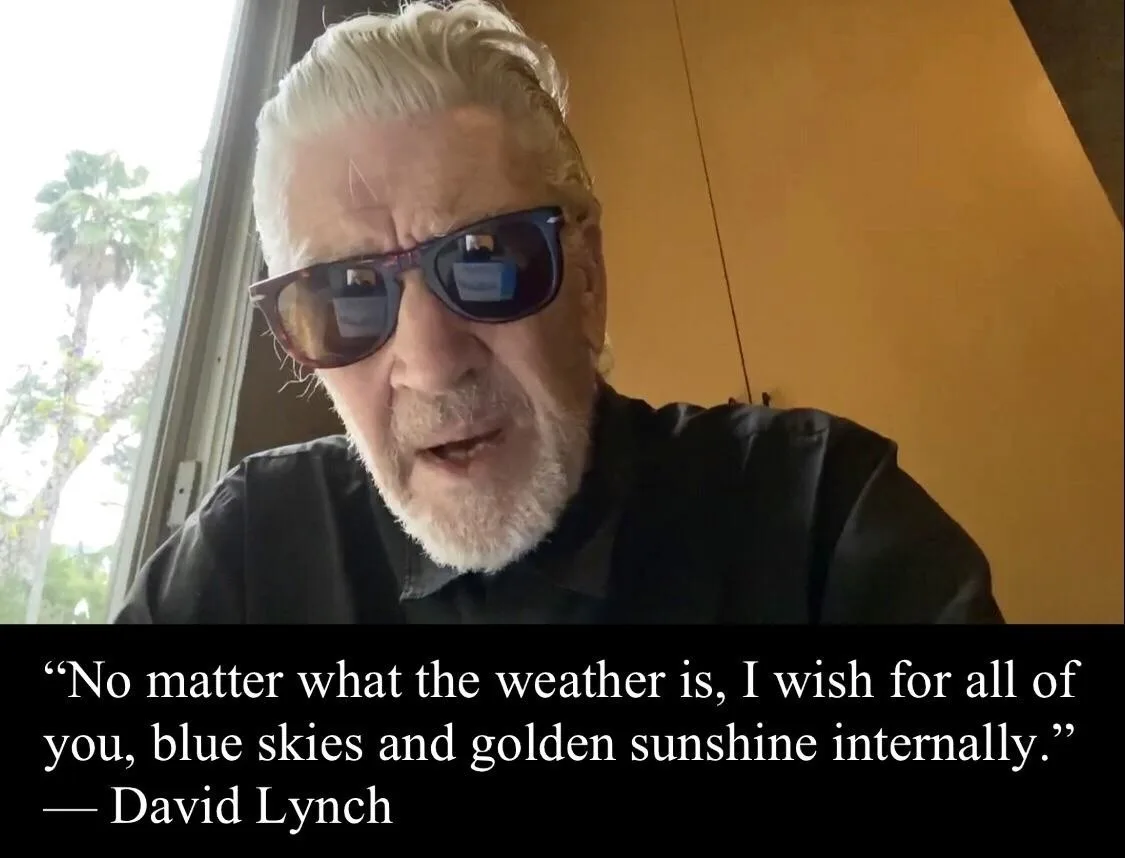 An older man with white hair and sunglasses is shown in a close-up, looking directly at the camera. He wears a black shirt…