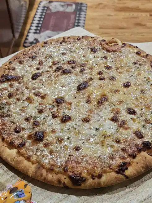 A close-up photo of a cheese pizza with golden-brown, bubbly cheese and a slightly charred crust, resting on a wooden board…