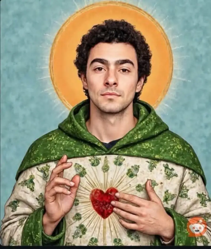 A man with curly dark hair and a calm expression is depicted in a saintly portrait, wearing a green hooded robe over a white…