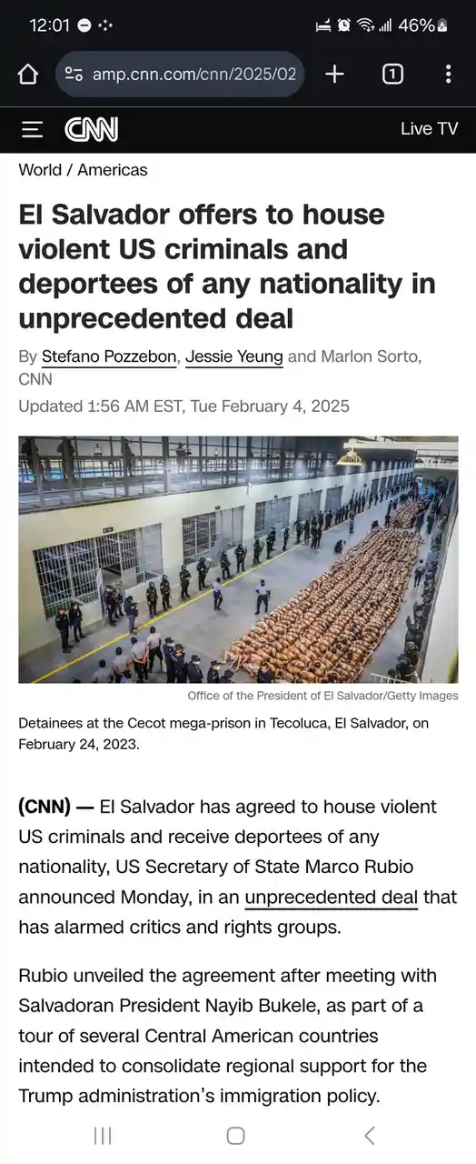 The image shows a large group of shirtless detainees lying on the floor in a prison yard, surrounded by uniformed officers…
