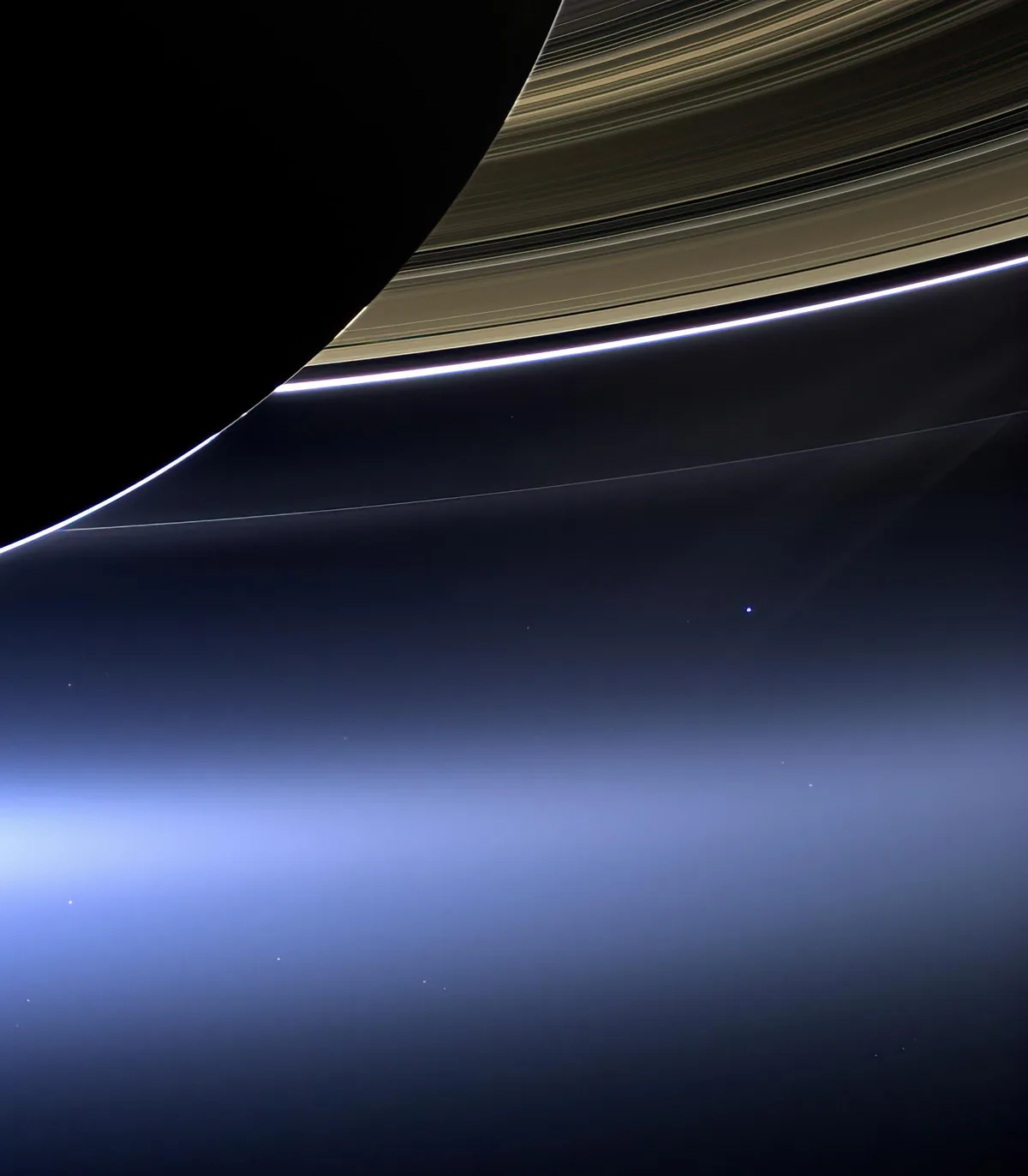 A stunning space photograph shows the rings of Saturn curving across the frame, with a bright, glowing edge along the rings…