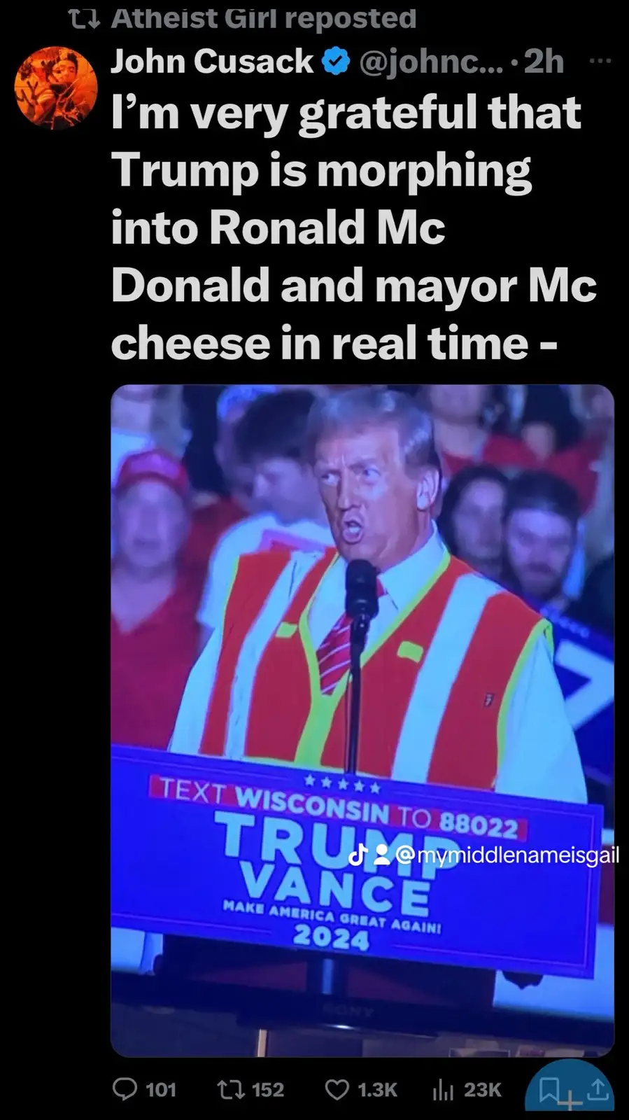 A screenshot of a tweet by John Cusack shows a photo of Donald Trump speaking at a rally, wearing a red and yellow striped…