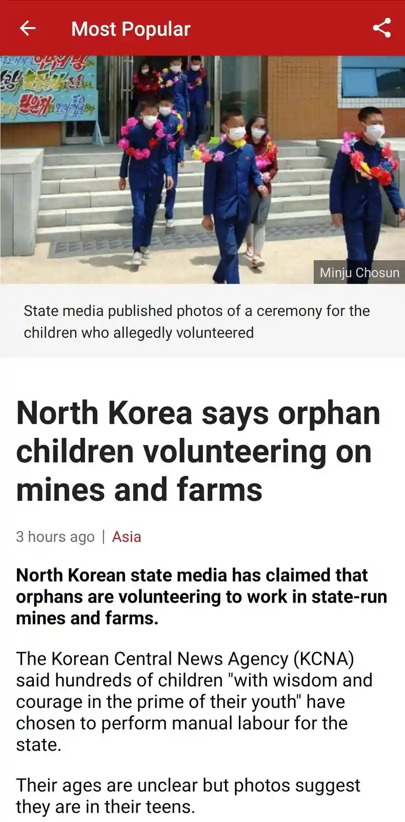 A screenshot of a news article shows a photo of several children in blue uniforms and face masks walking down steps while…