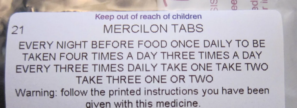 A close-up of a Mercilon Tabs medication label with confusing, contradictory dosage instructions like 'every night before…