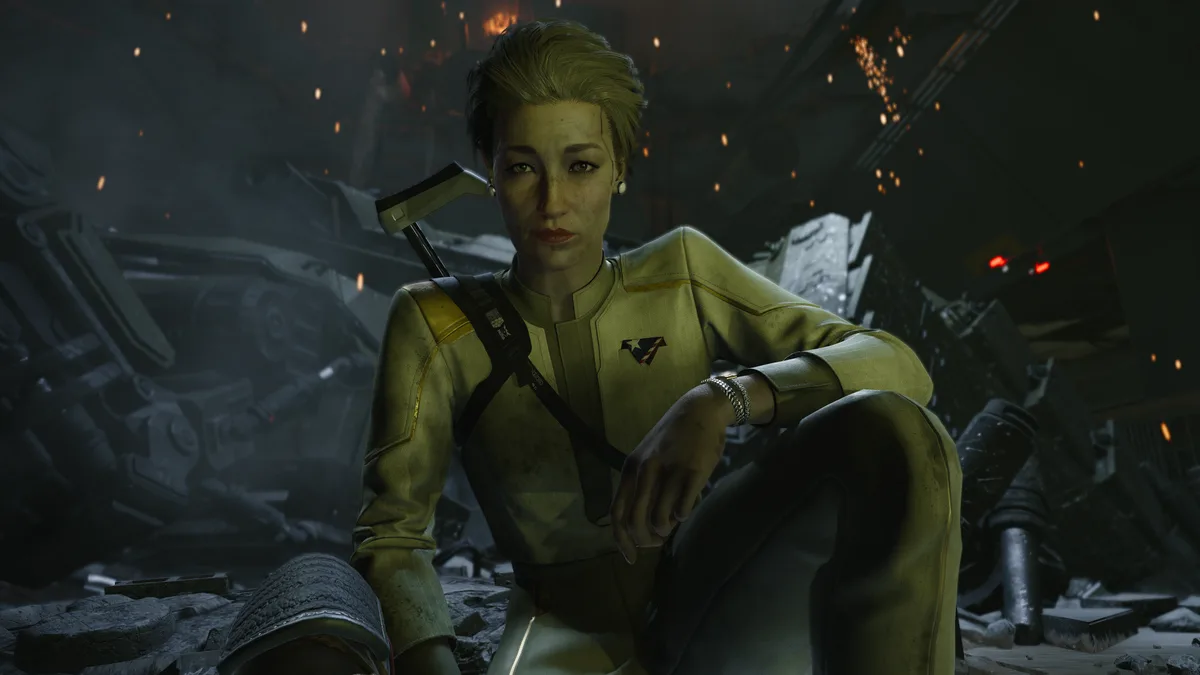 A woman in a yellow uniform sits amidst rubble and sparks in a dark, damaged environment, looking directly at the viewer…