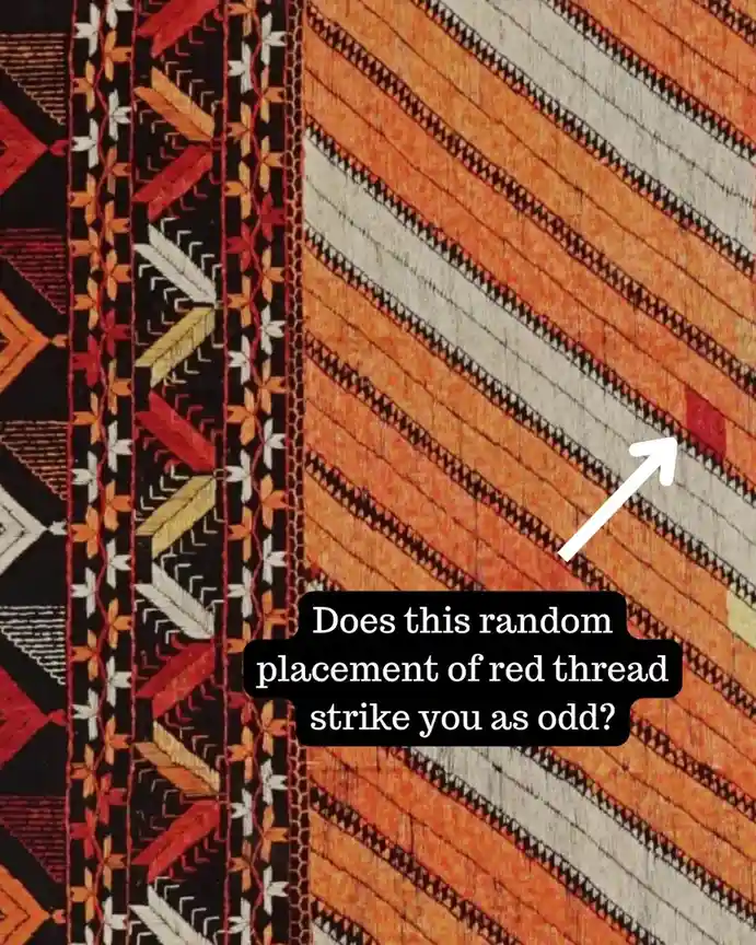 A close-up of a colorful, geometrically patterned textile with diagonal stripes of orange, beige, and black, featuring…