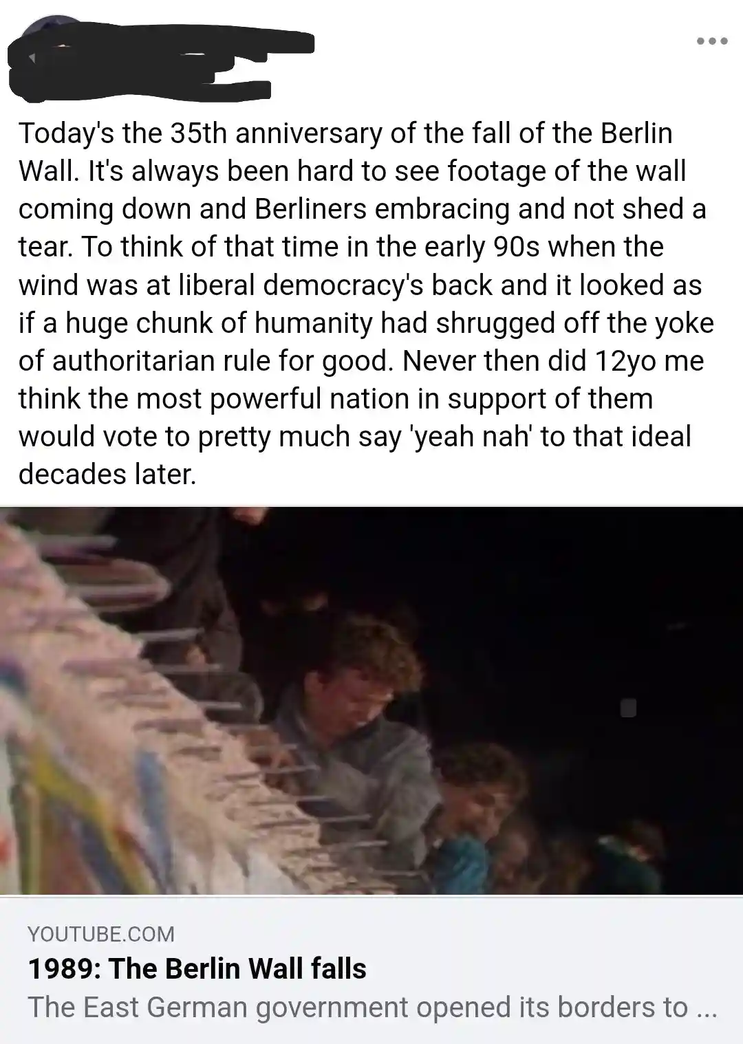 The image shows a dimly lit, grainy video still from a historical event, likely the fall of the Berlin Wall in 1989…