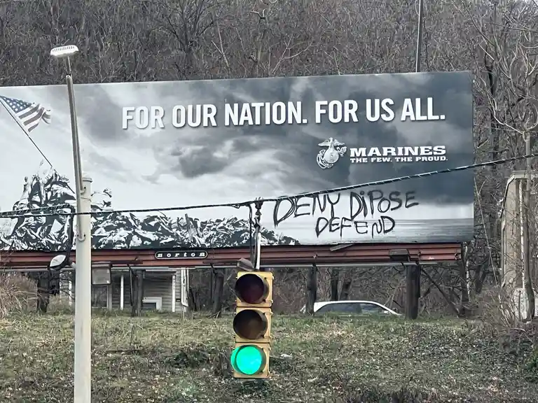 A large military billboard for the Marines with the slogan 'FOR OUR NATION. FOR US ALL.' and an image of the Iwo Jima…