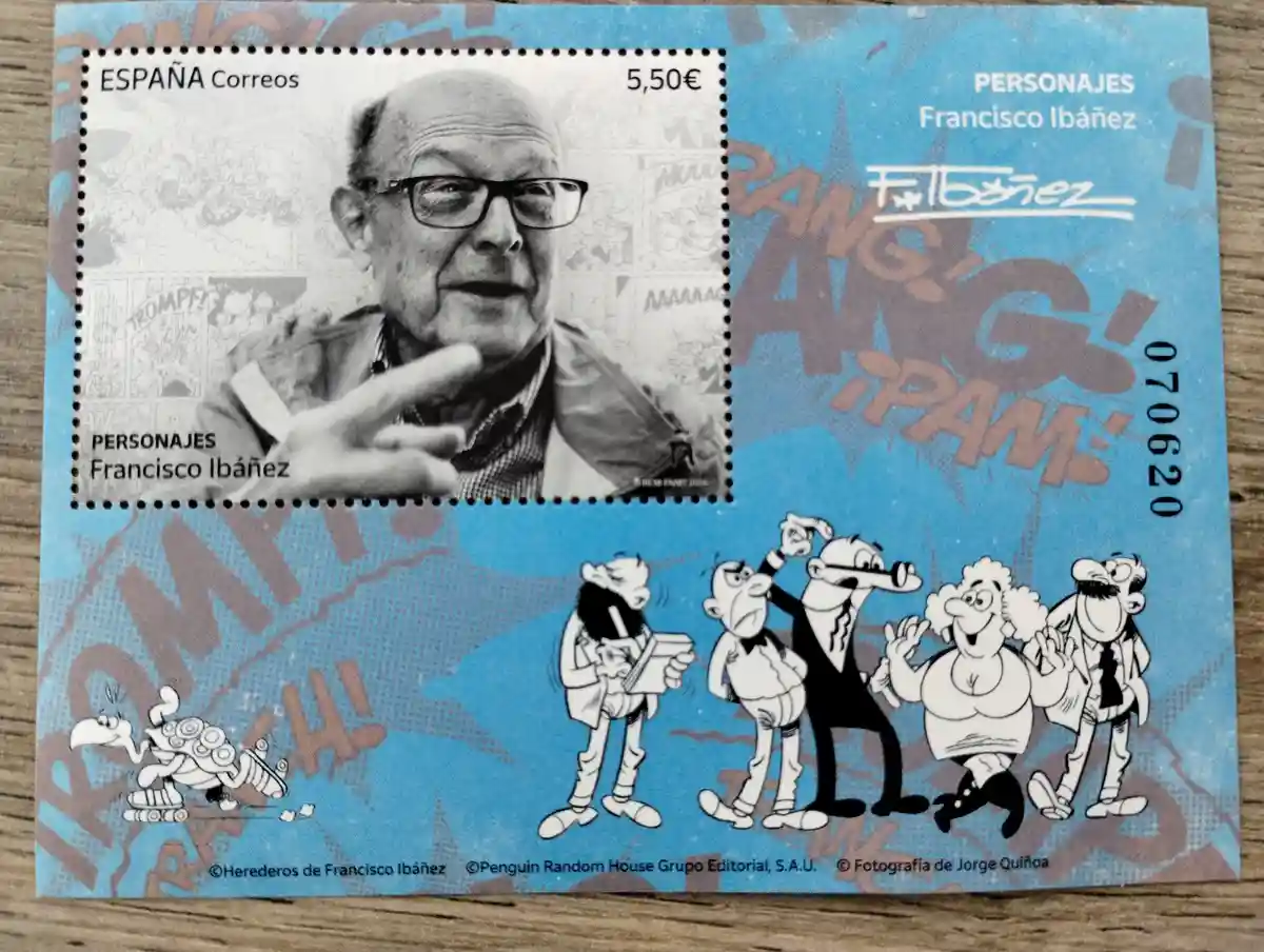 A Spanish postage stamp featuring a black-and-white photo of cartoonist Francisco Ibáñez, with his signature comic…
