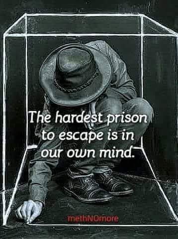A black-and-white chalk drawing shows a man in a hat and jacket crouched inside a transparent cube, appearing trapped. The…
