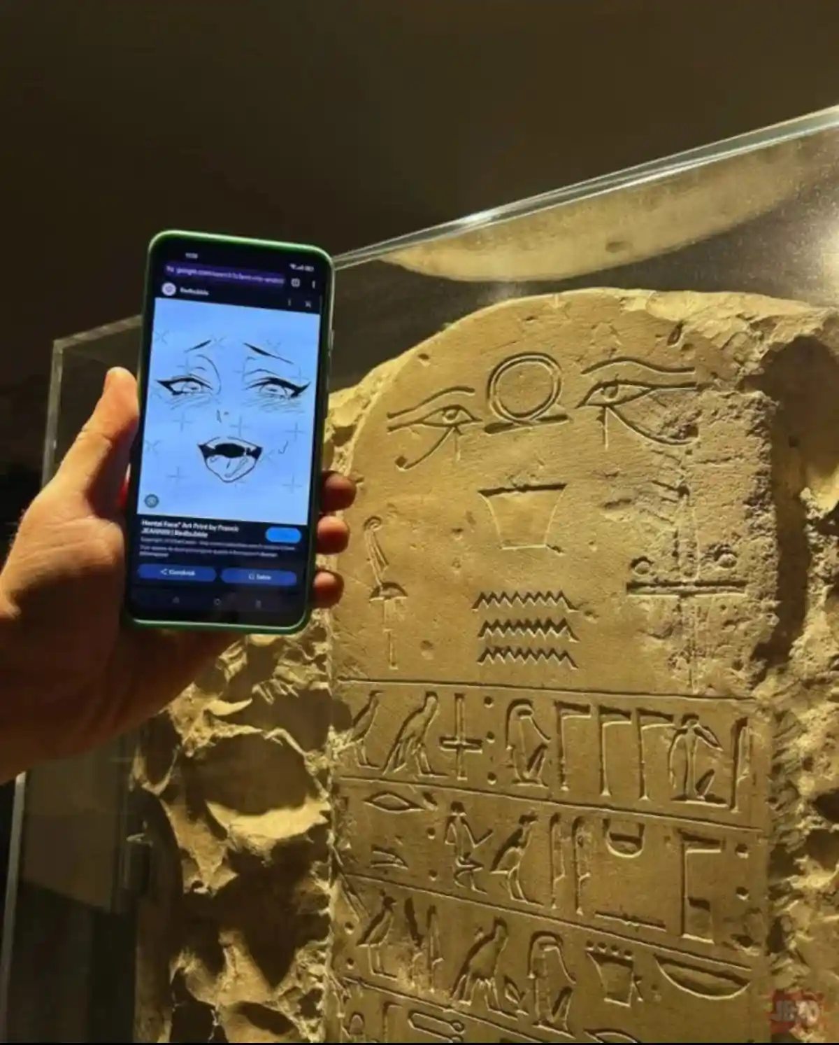 A hand holds a green smartphone displaying a cartoonish anime-style face with exaggerated eyes and mouth, overlaid on an…