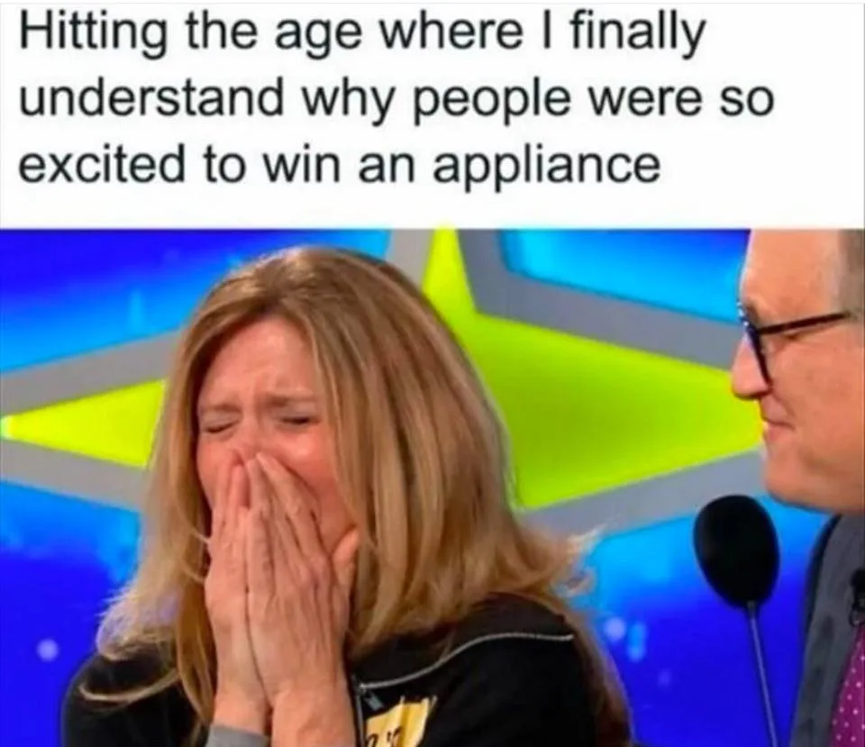 A woman with blonde hair is visibly crying with her hands covering her face, seated next to a man in glasses and a suit on a…