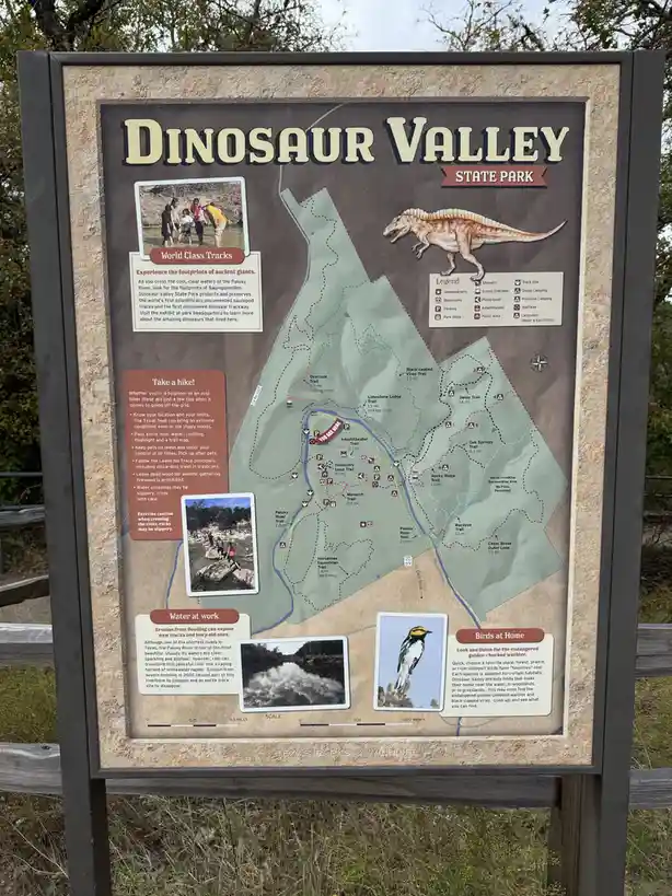 A park map for Dinosaur Valley State Park shows trails, facilities, and a legend, with a red arrow pointing to a location…