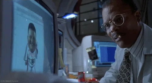 A man in a white shirt and patterned tie, wearing round glasses, is shown in a sequence of four panels looking at computer…