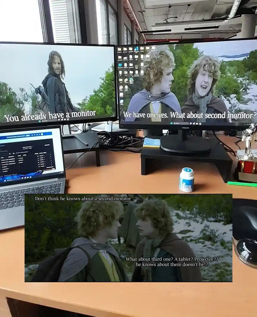 An office desk setup with two monitors and a laptop, each displaying a scene from 'The Lord of the Rings' with overlaid…