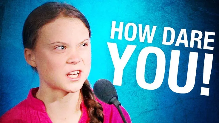 A close-up image of a young woman with dark hair in a braid, wearing a pink top, standing before a microphone with an angry…