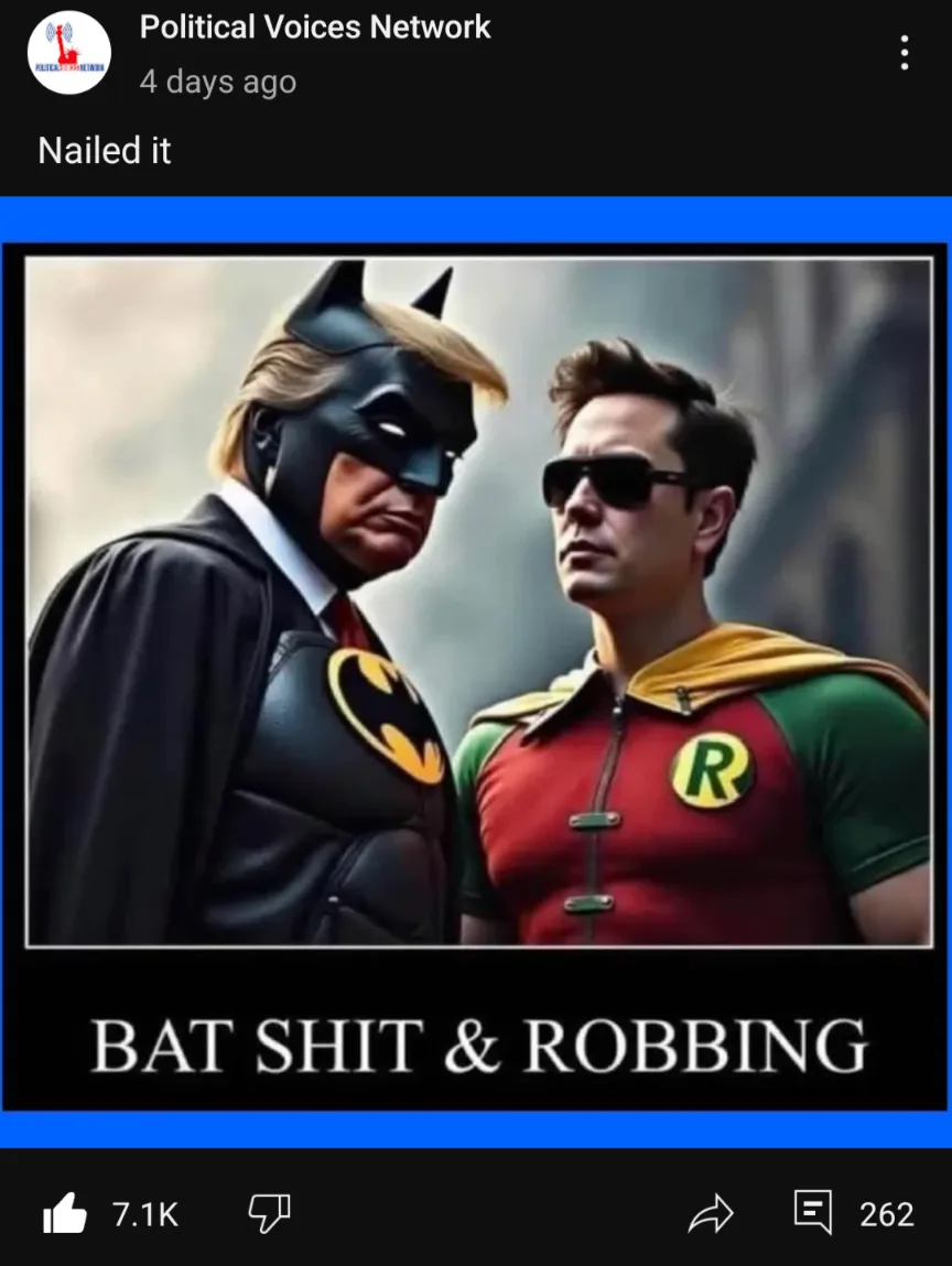 The image shows two men dressed as Batman and Robin. The Batman figure has a blonde wig and a stern expression, while the…
