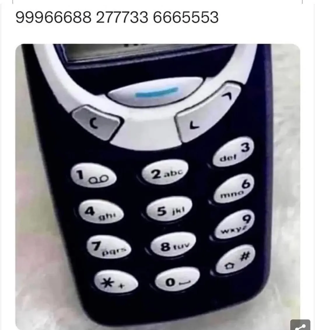 A close-up of a black and silver Nokia-style feature phone keypad with white buttons showing numbers and letters. The…