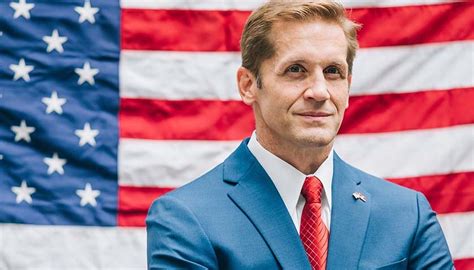 A man in a blue suit and red tie stands in front of an American flag, smiling slightly. The overlaid text reads 'i'm not a…