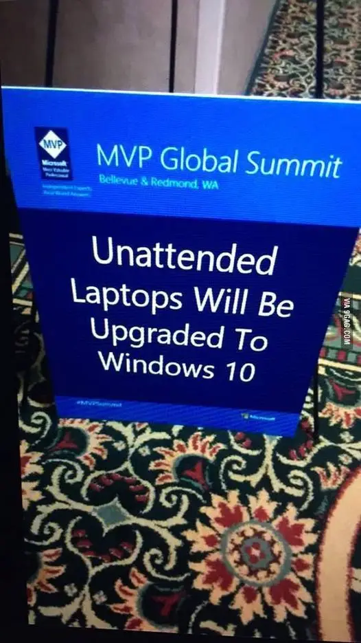 A blue Microsoft MVP Global Summit sign at an event in Bellevue & Redmond, WA, displays a warning that unattended laptops…