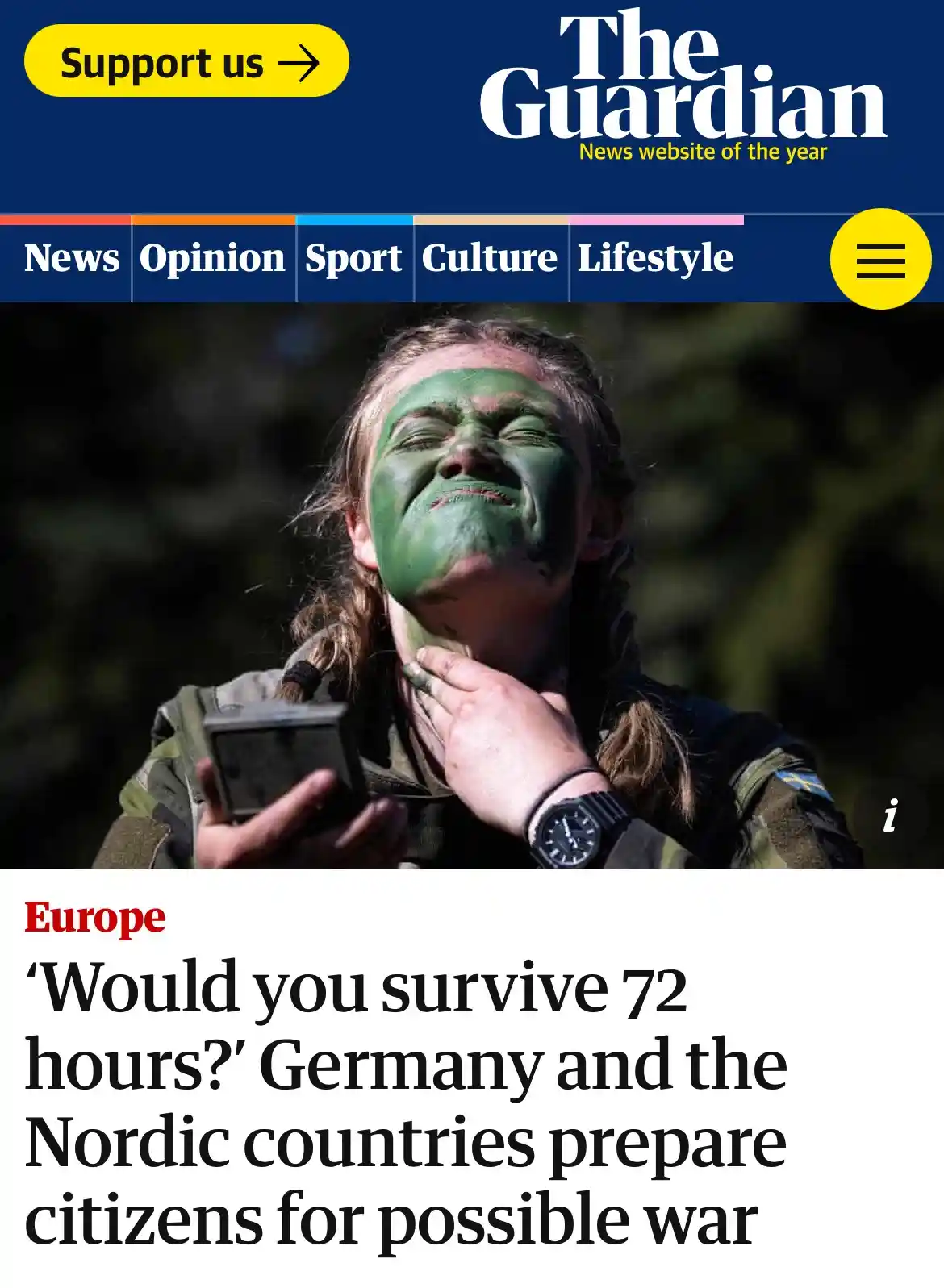 A screenshot of The Guardian news website shows a woman with green camouflage paint on her face, eyes closed and grimacing…