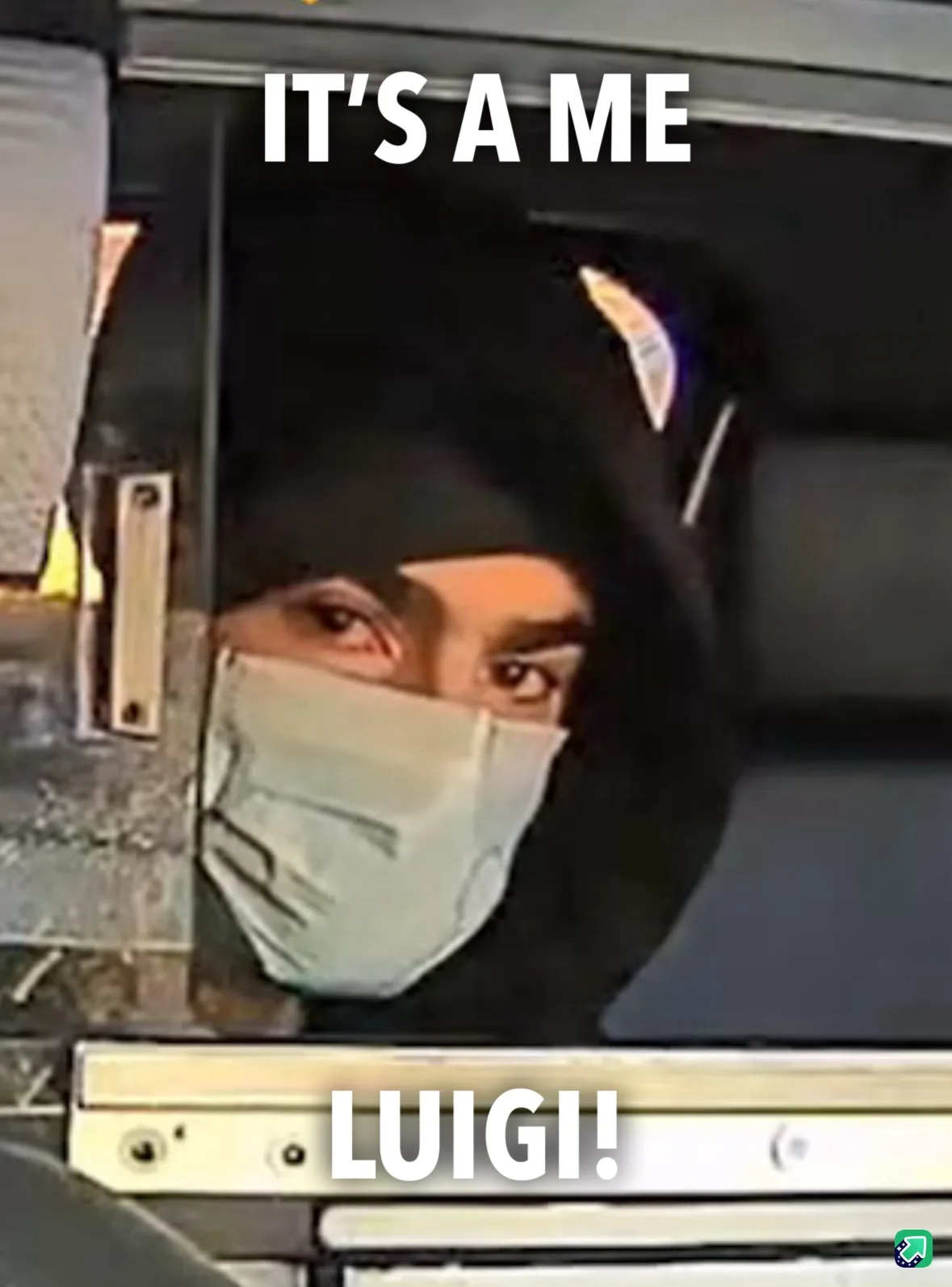 A person wearing a black beanie and a light-colored face mask peers out from inside a vehicle, with the text 'IT'S A ME' at…