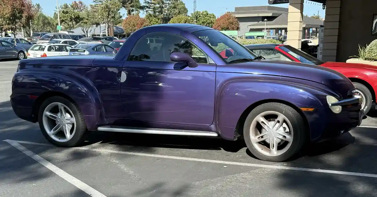 A shiny purple Chevrolet SSR, a two-door convertible pickup truck, is parked in a sunny lot. The overlaid text reads 'i'm…